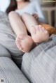 A woman sitting on top of a couch with her feet up.