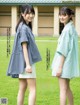 A couple of young women standing next to each other in a field.