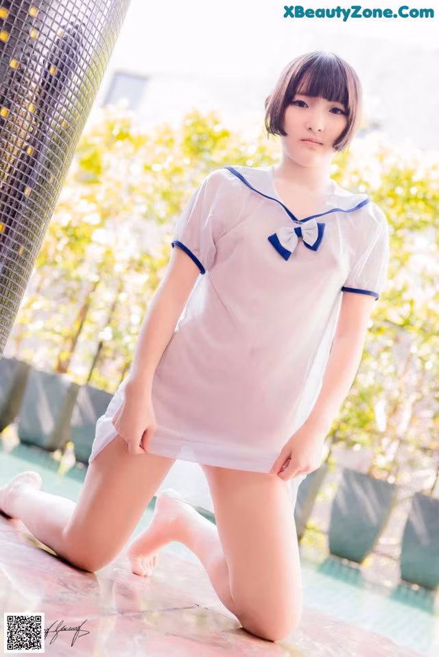 A woman in a white dress is posing for a picture.