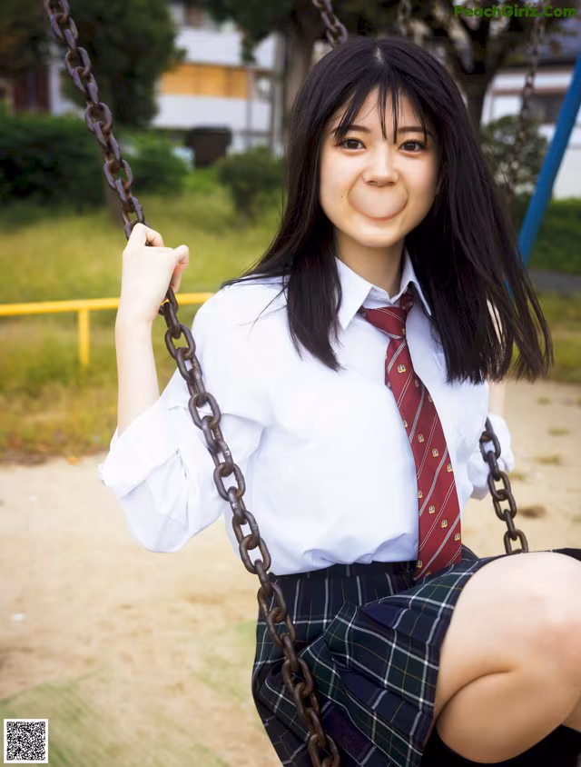 A woman in a school uniform sitting on a swing.