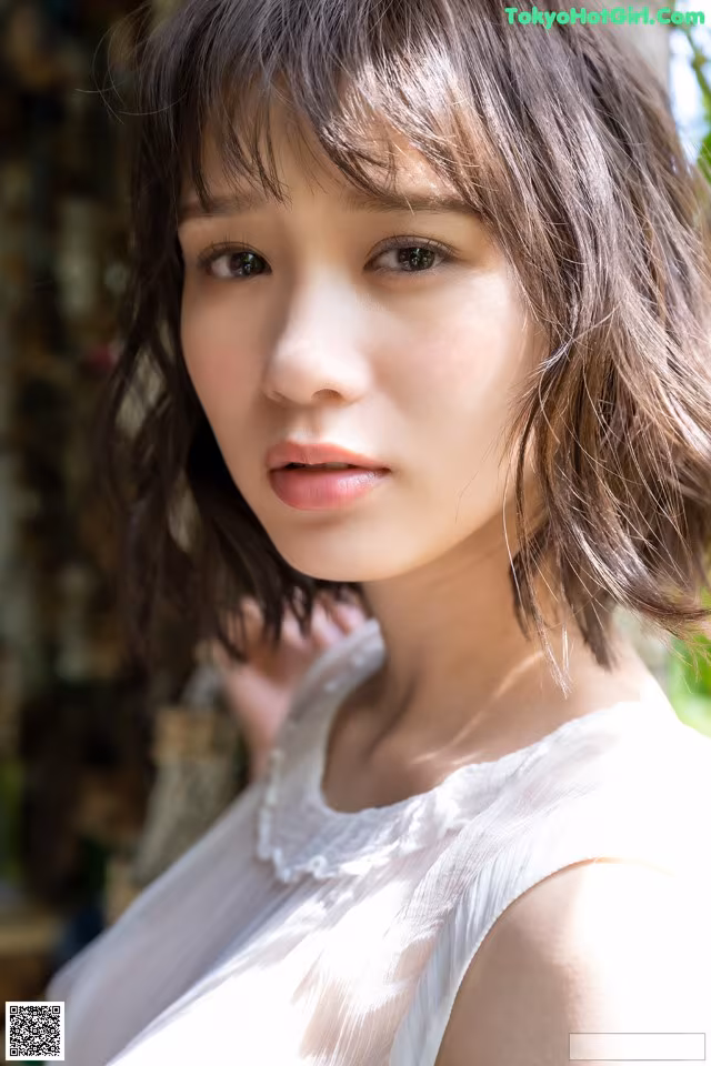A woman in a white dress posing for a picture.