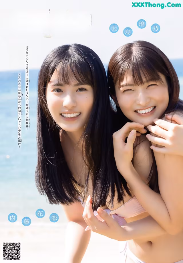 A couple of young women standing next to each other on a beach.