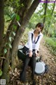 A woman sitting on a bench in the woods.