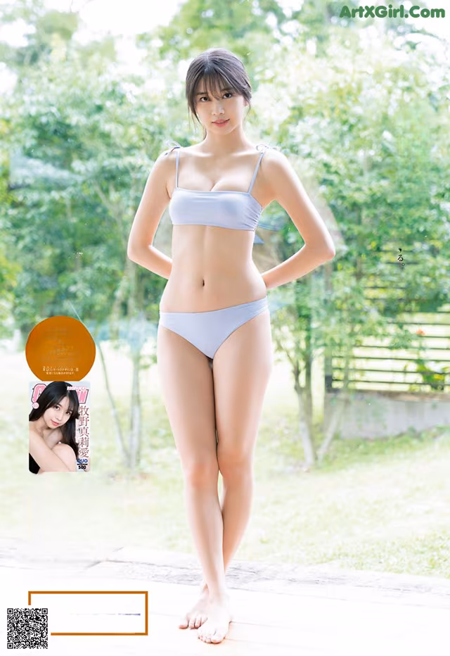 A woman in a blue bikini standing on a wooden deck.