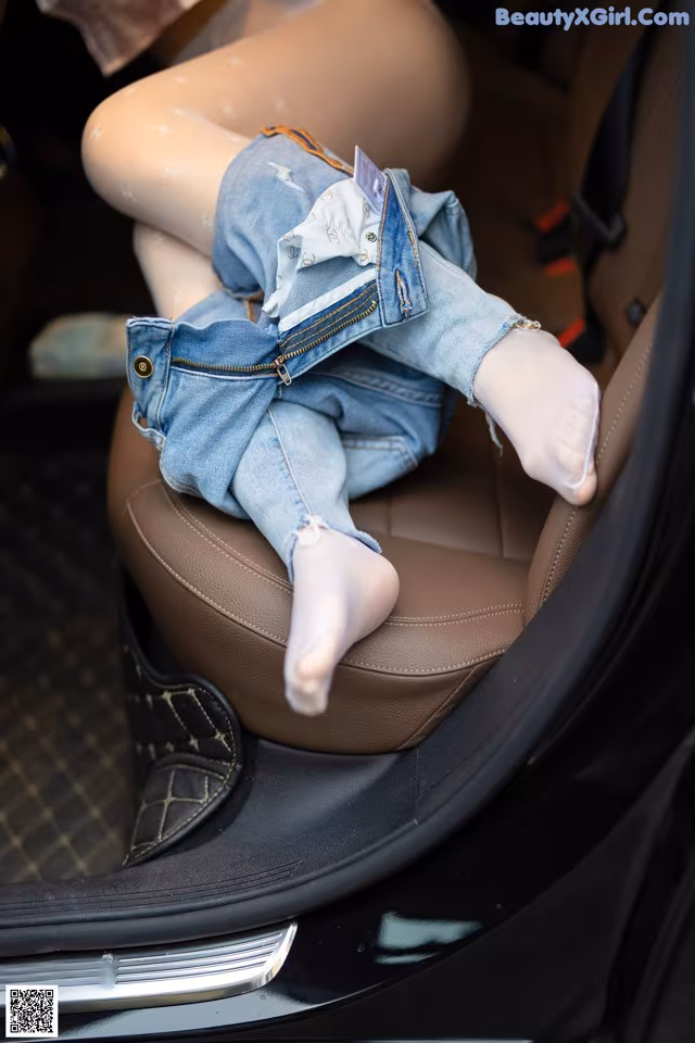 A baby is sitting in the back seat of a car.